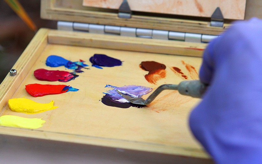 Jane Boyd mixes paint together on her palette.