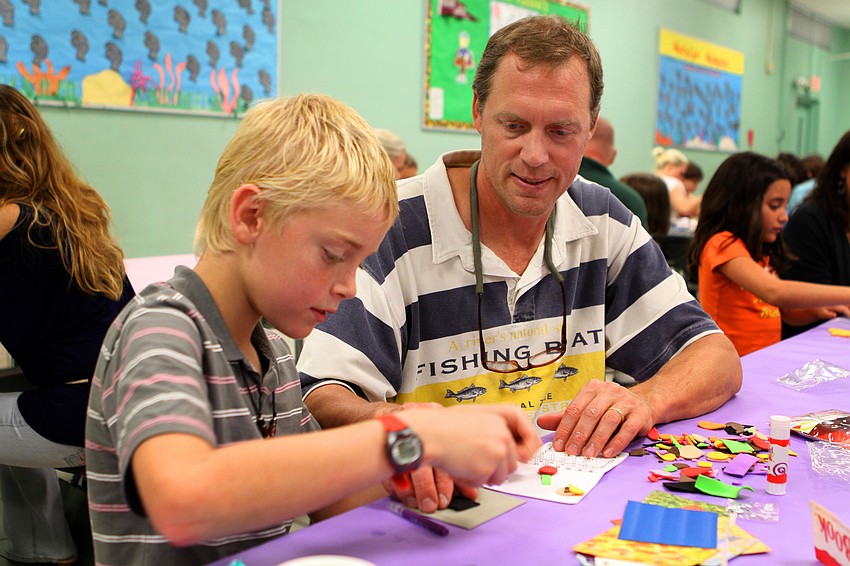 Daniel Lange, 9, and his dad, Ken, work on making a book about soccer.
