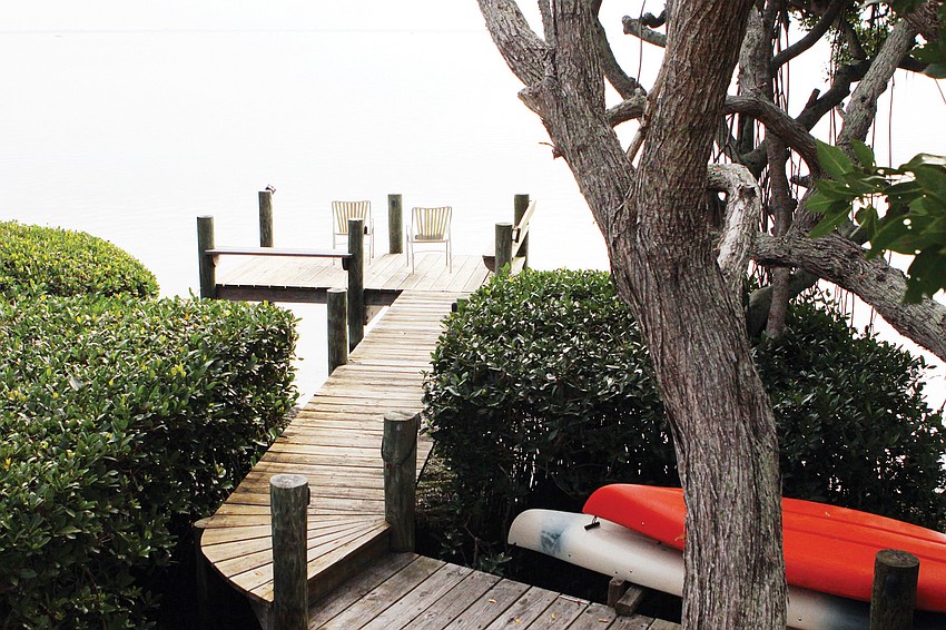 Two chairs are placed at the end of the dock for a prime viewing spot of the natural setting.