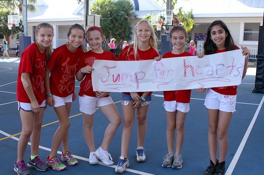 Natasha LaLiberty, 12, Hannah Bizick, 11, Gracie Schlotthauer, 10, Caroline Lafor, 10, Sydney Hill, 10, and Chelsea Lea, 9, pose together with their banner and matching t-shirts.