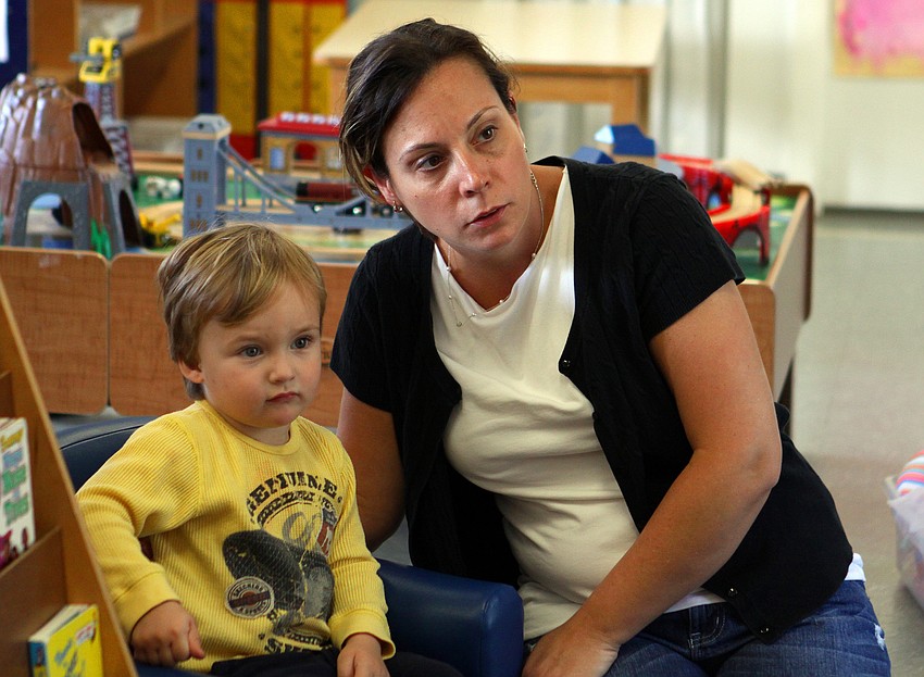 Henry Gilbertson, 2, and Barbara Papantonakis listen as Nancy Velazquez and Michele Guffanti from the Gulf Gate Library read and act out a story, Monday, Feb. 27, at St. Boniface Preschool.