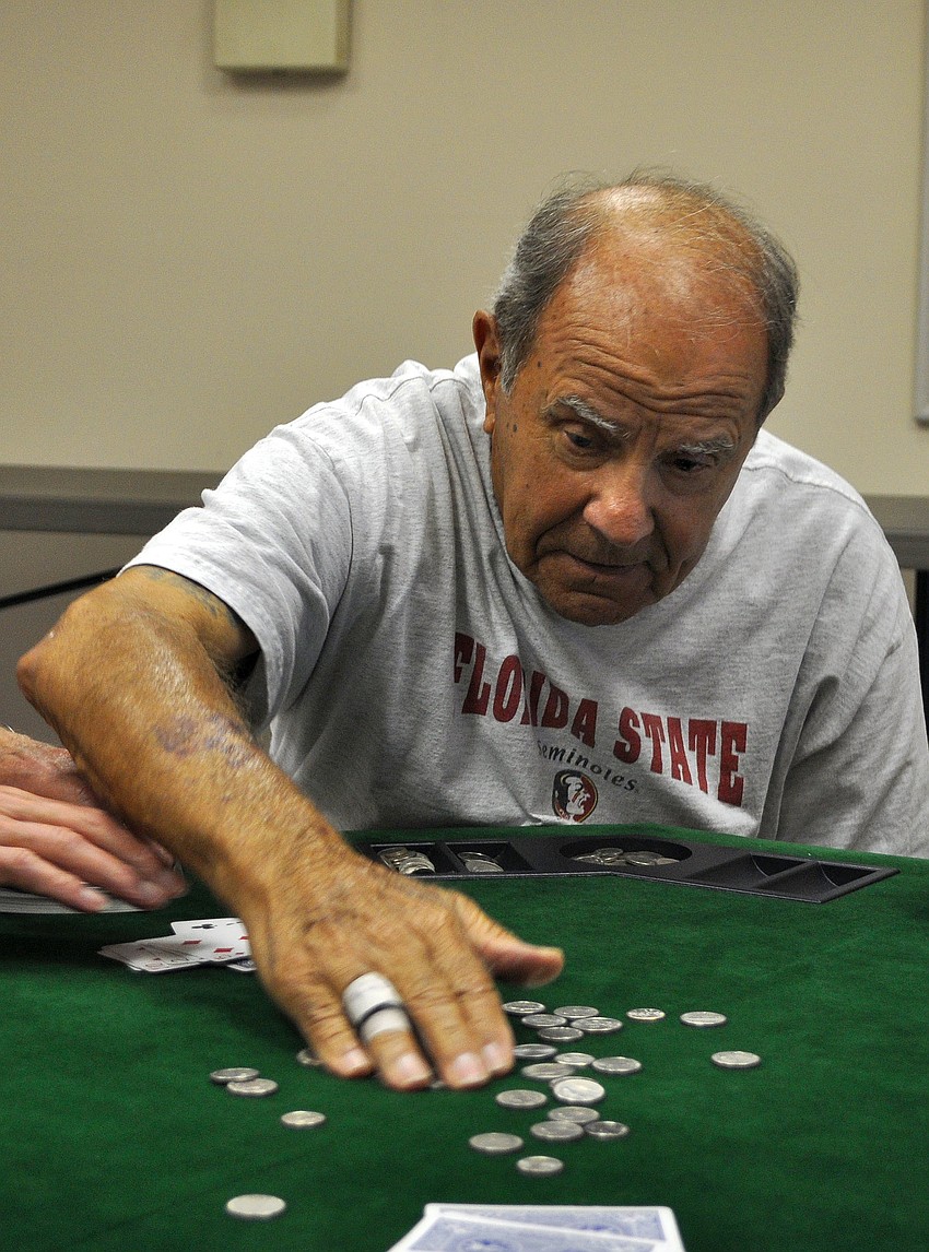 Joe Figluizzi gathers up the change he won during a game, Tuesday, March 27, at Midnight Cove II.