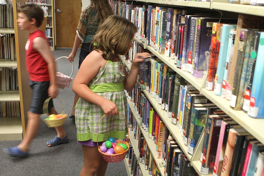 Catherine Parrott, 9, looks behind books in hopes of finding the golden egg.