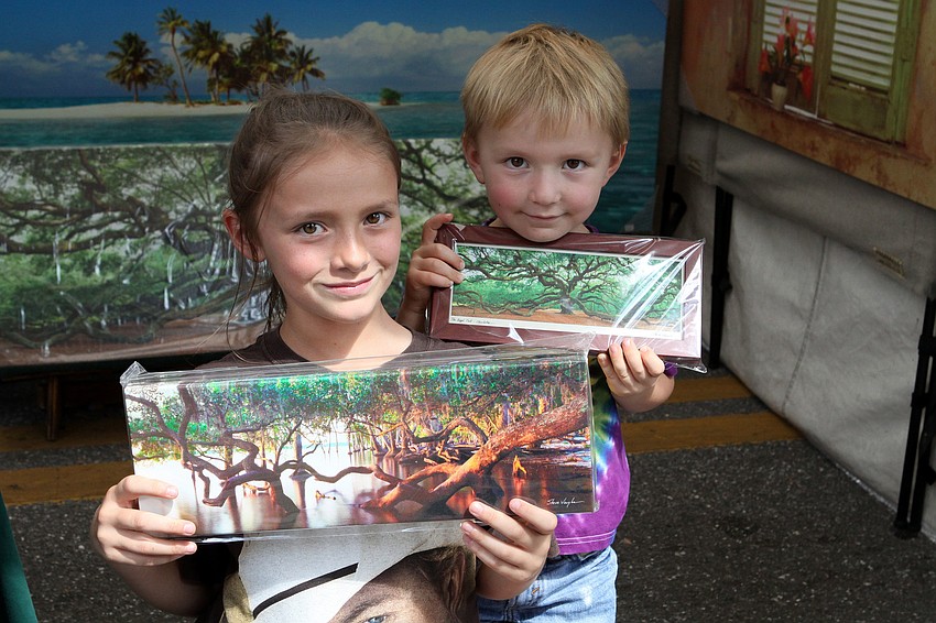 Tobi, 10, and Cooper, 3, Dydra show off the photos they were going to get from the Steve Vaughn Panoramic Photography booth.