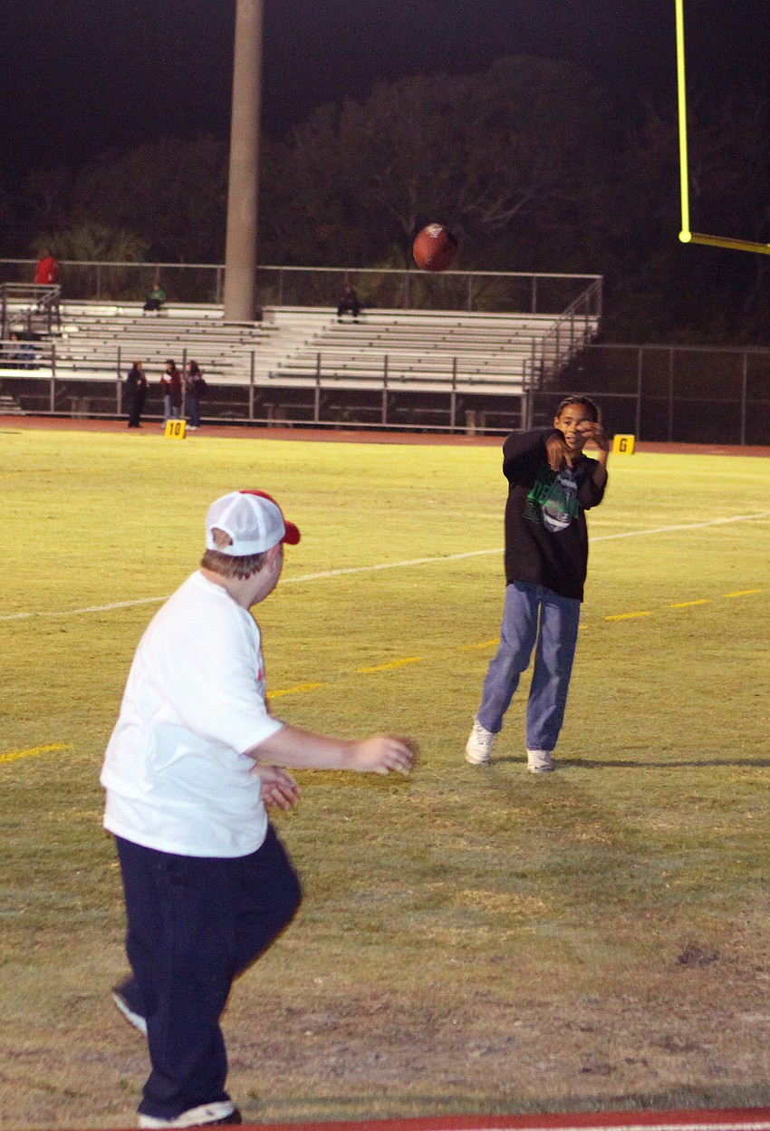Jerecho Ramos, 12, throws the ball to Brian Greer, 10, before the game, Friday, Jan. 6, at Booker High. Both boys were ball boys for the 20th Annual Brad Price Memorial PAL Bowl.