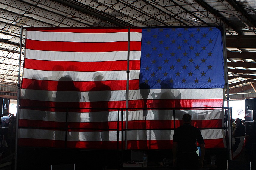 Members of different Republican groups throughout Sarasota and Manatee counties are silhouetted through a big American flag.