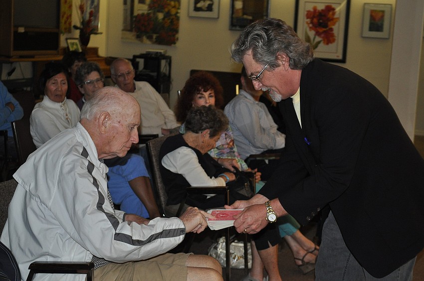 Chandler asks an audience member to select a card