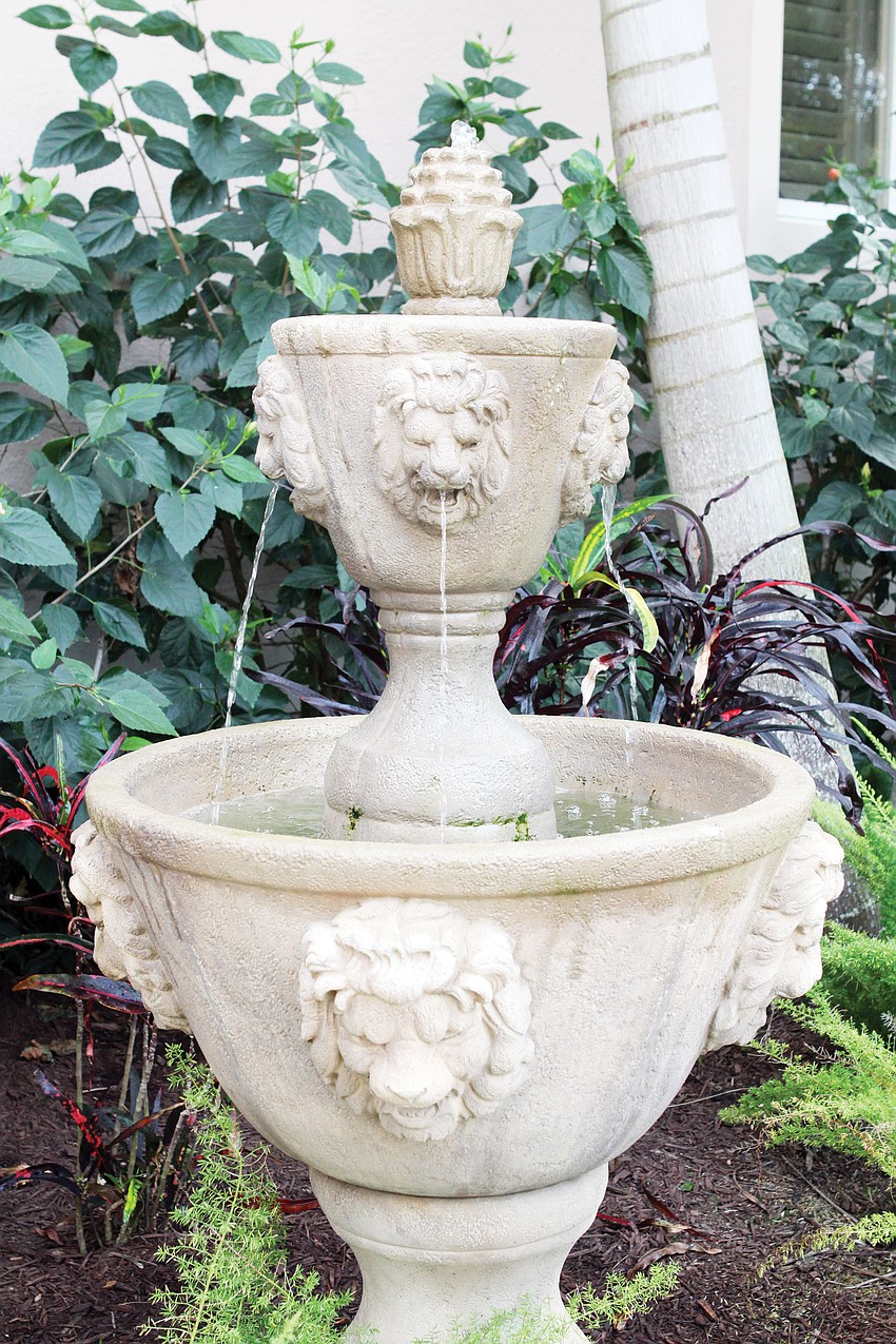 The owners of the home installed a fountain near their front door that features lion faces.