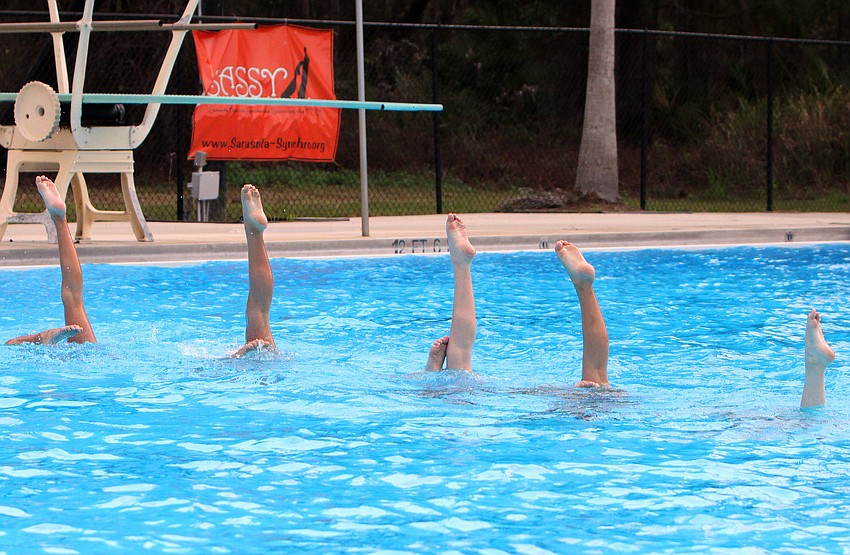 The 11-12 group do a bent knee during one of their performances, Sunday, Feb. 19, at the Selby Aquatics Center at the Sarasota Family YMCA.