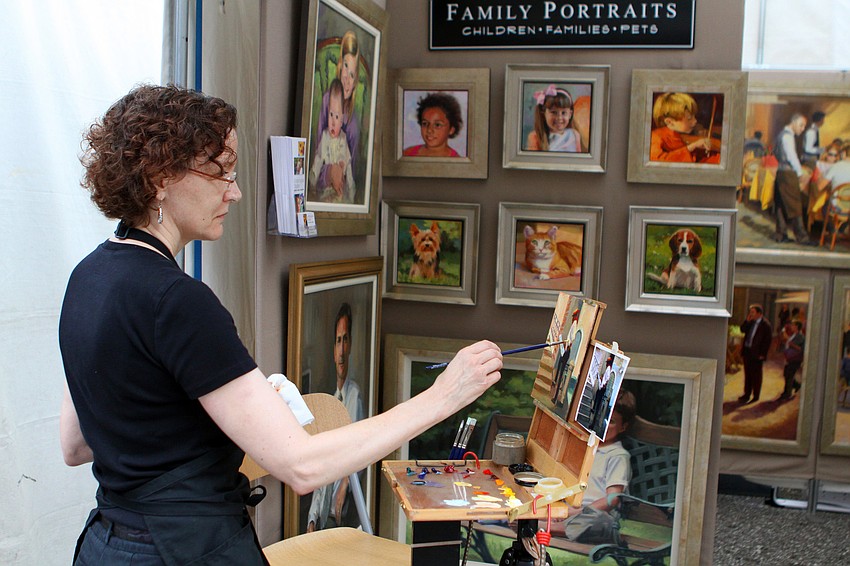 Linda Hugues works on a painting at her tent.