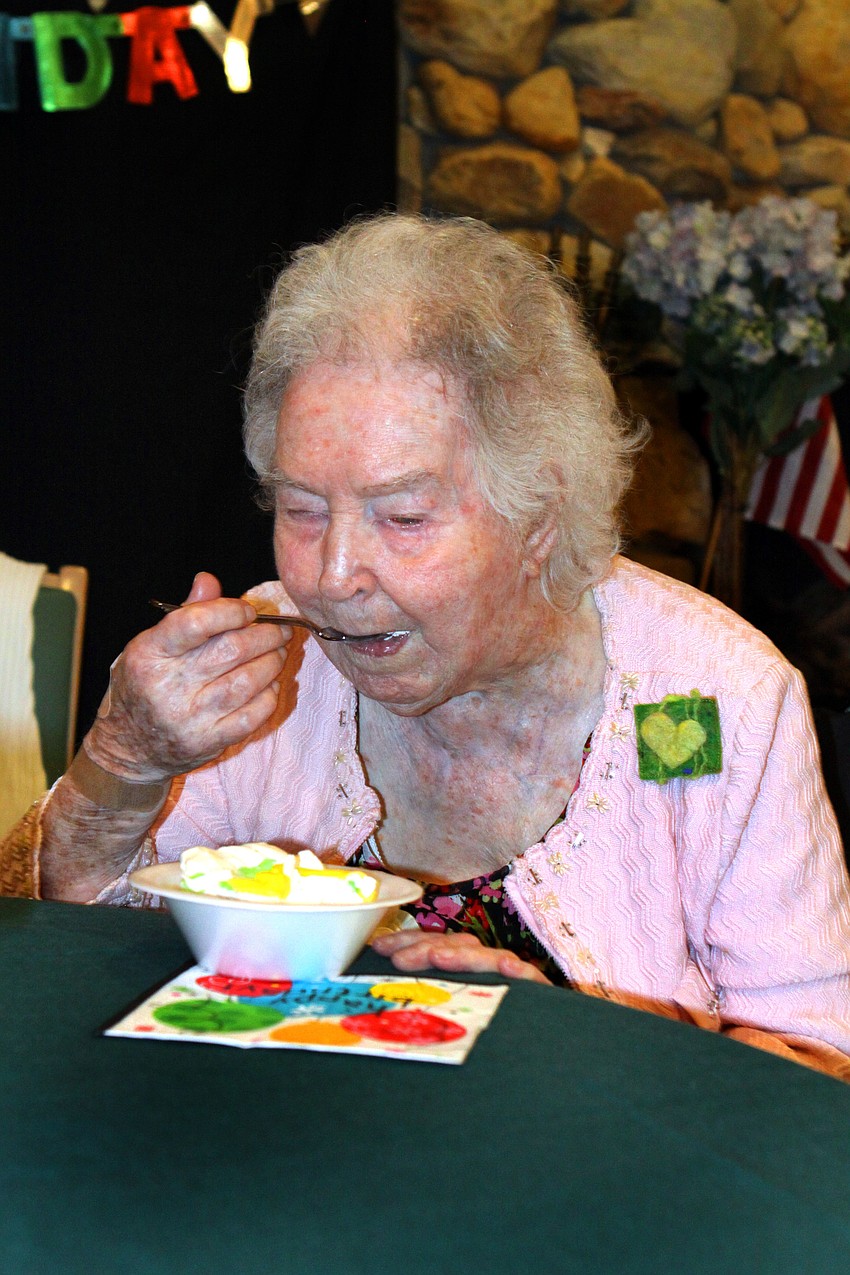 Elizabeth Delaney takes her first bite of ice cream and birthday cake, Monday, March 12, at the Senior Friendship Center.