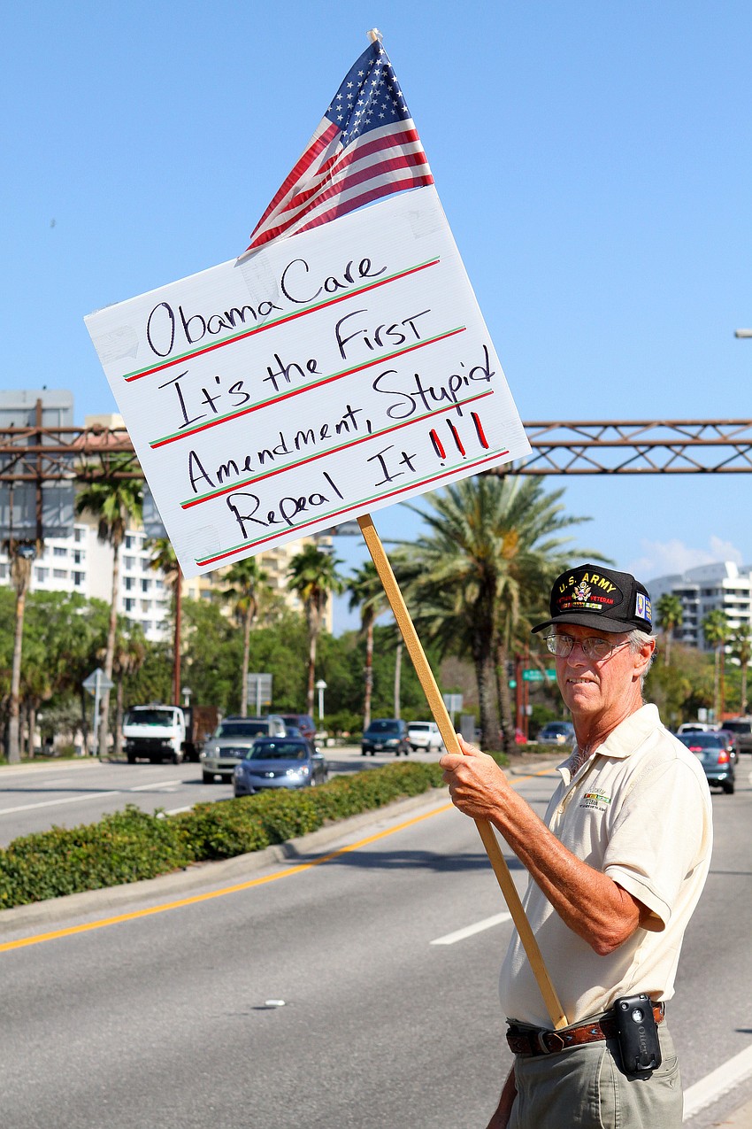 Ed Sterba holds up his sign, Friday, March 23, along 41.