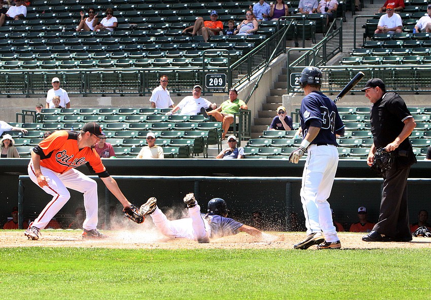 Jason Hammel attempts to tag Orlando Rivera as he stole home plate. Rivera ended up being called safe.