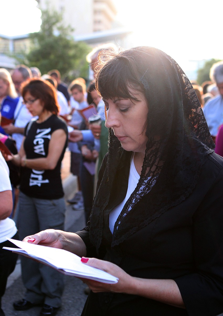 Katherine Orenic reads from the Stations of the Cross book that was given out to all the participants in the Stations of the Cross walk.