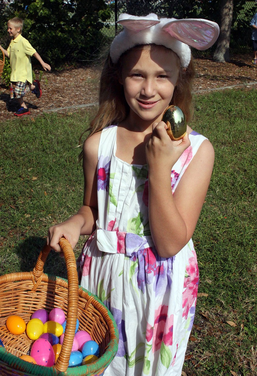 Nicole Norwine, 8, shows off the golden egg she found, Saturday, April 7, during the egg hunt at St. Michael the Archangel.