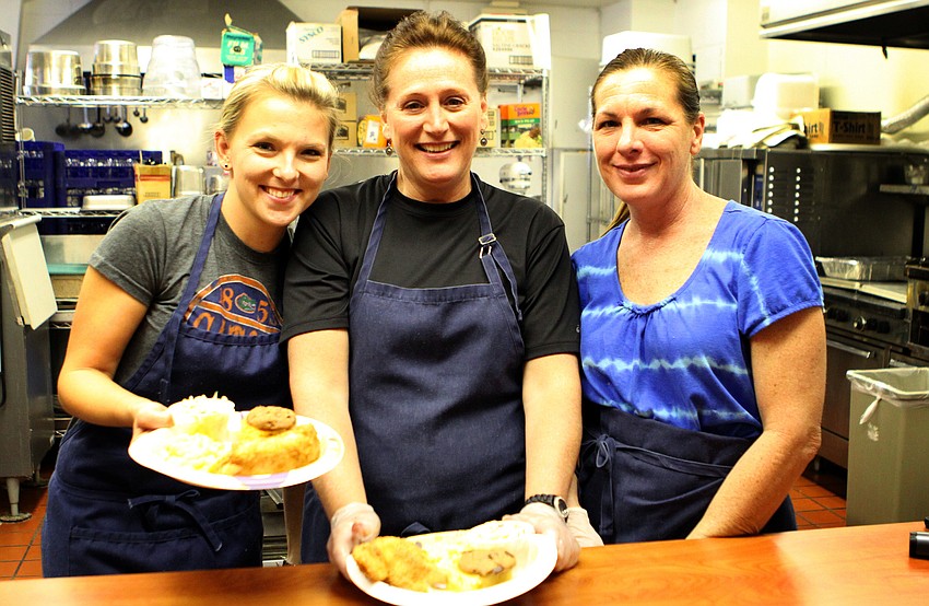 Missy Williams, Marcia Meerman and Jane Holcomb of Walker Family Catering hold up fish fry dinner plates.