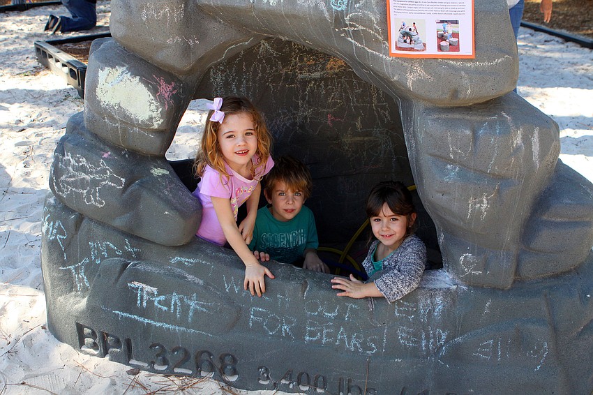 Brooke Hall, 5, Blake Norman, 5, and Lila Tack, 4, play inside the Cave Boulder, one of the many new pieces of playground equipment at Forty Carrots.