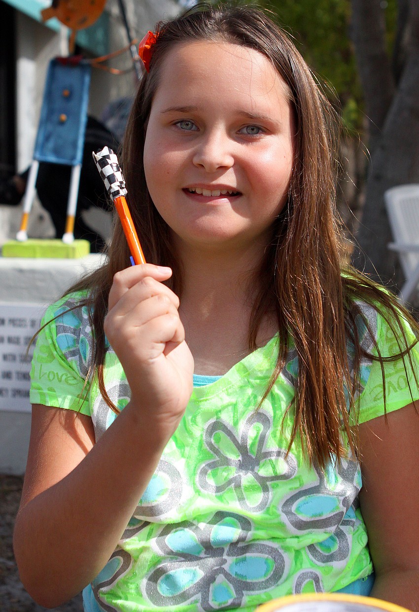 Destiny Parrish, 10, shows off one of her duck tape pen creations that she sold at the Siesta Key Craft Festival.