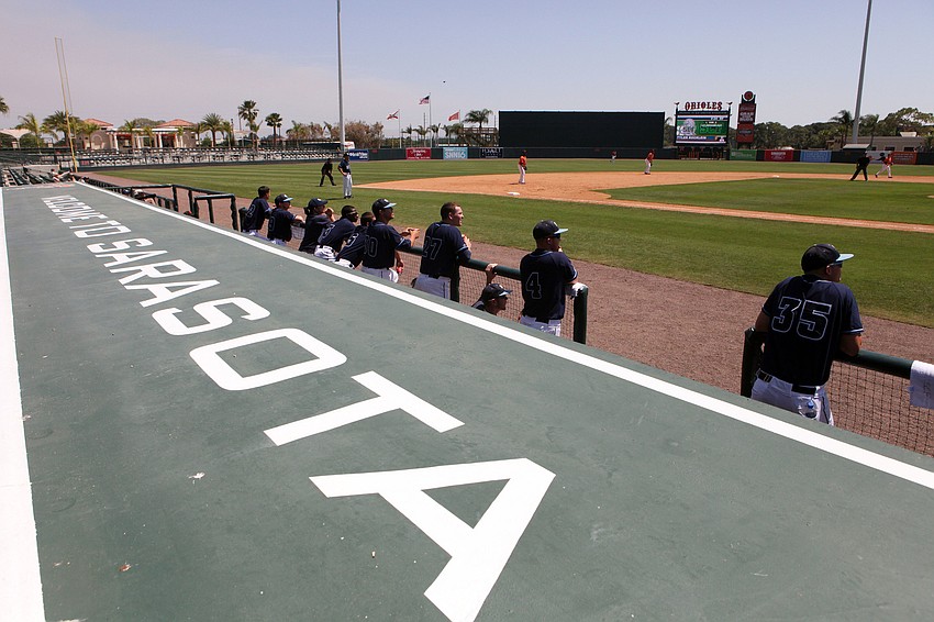 The SCF Manatees watch their teammates and the Baltimore Orioles from the visitorâ€™s dugout, Tuesday, April 3, during a charity baseball game.