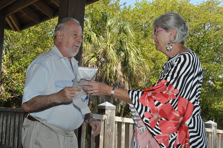 Judy Williams gives a thank you gift to Bob Garvin for participating in the Home and Garden Tour
