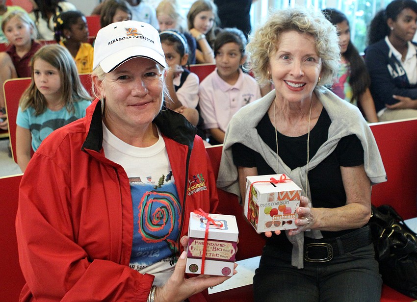 Lynn Jones and Vicki Eckl show off their banks made by the girls at Girls Inc.