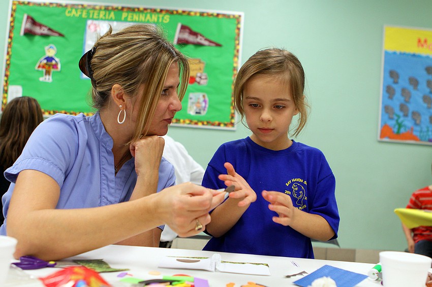 Elizabeth and Brooke Wright, 6, try to figure out which foam pieces would work best to make a dog.