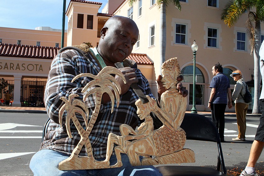 Derrick Mutisya works on carving a piece for a family collection he is working on, Saturday, Jan. 28 at the 14th annual Downtown Sarasota Art in the Park at Five Points Park.