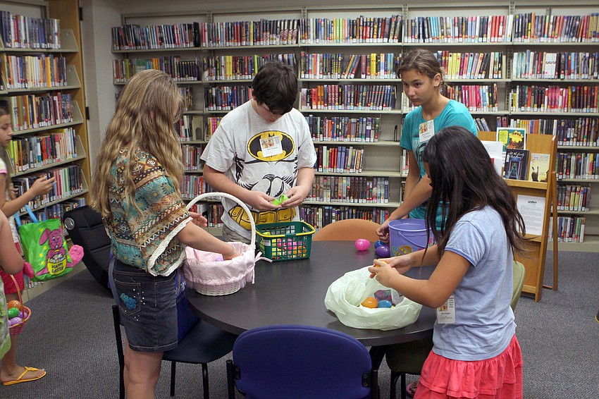 The older kids look through their plastic eggs to see what kind of candy and prizes they collected during the treasure hunt.