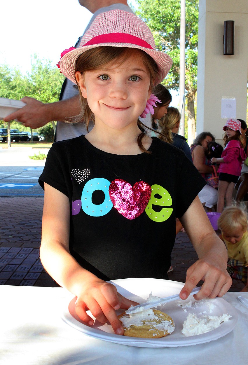 Ella Rochester, 7, has fun putting frosting on her cookie.