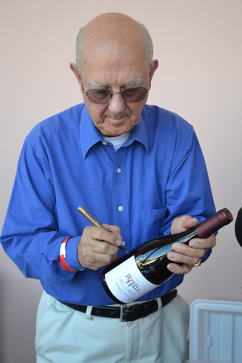 Robert Hall autographs one of his wines.