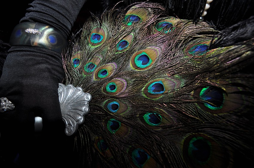 Pamela Swain wore an Alexis Bittar bracelet and carried a fan made of peacock feathers.