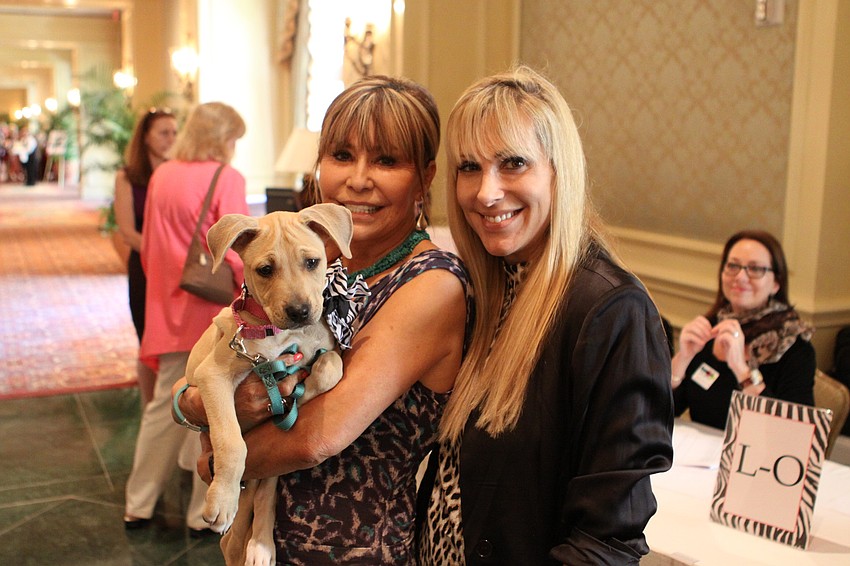 Chris Voelker and Alex Miller with Bonnie, one of the puppies up for auction at the 6th Annual Paws on the Catwalk.
