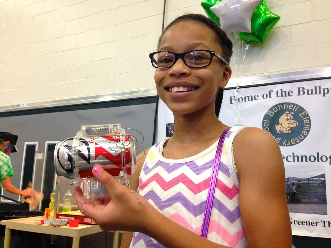 Karissa Jackson demonstrates the Soda Can Robug. See palmcoastobserver.com for a video of the bug in action. Photo by Brian McMillan