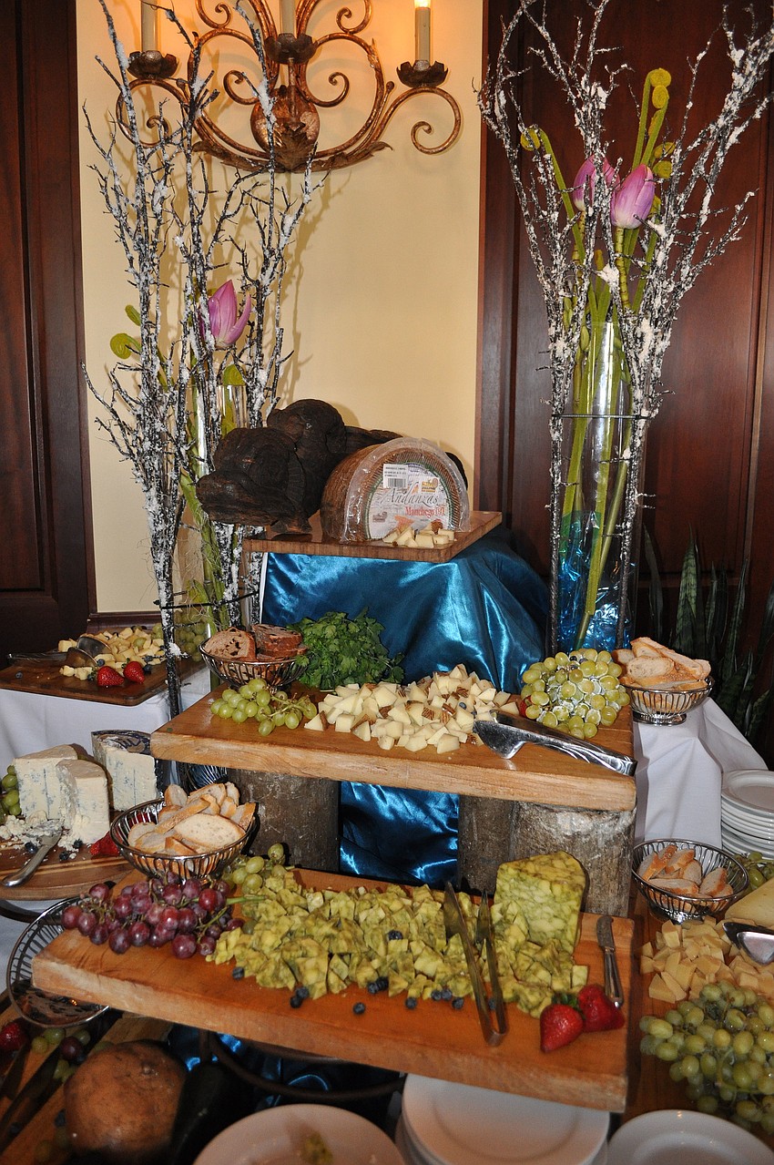 A beautiful display of cheeses, crackers and fruit.