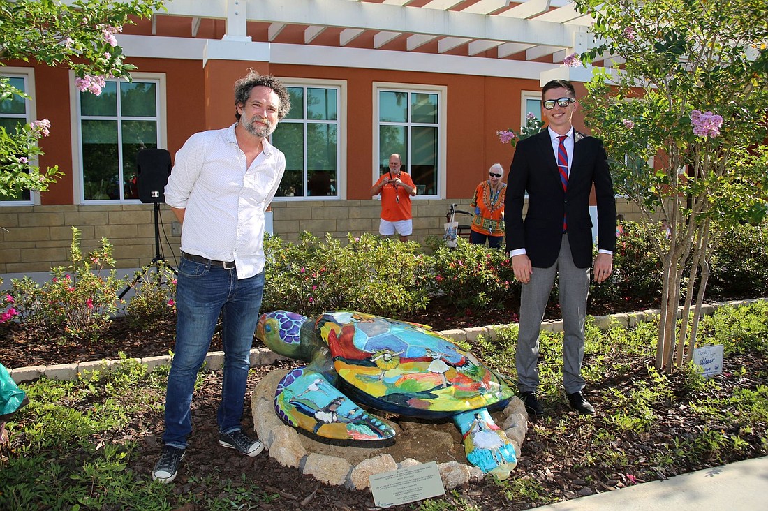J.J. Graham poses with the turtle he painted, along side City Councilman Nick Klufas, in 2019, outside City Hall. Courtesy photo