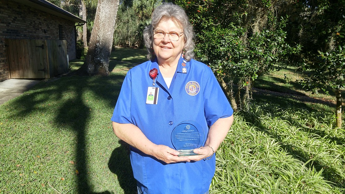Patty Mercer, a volunteer with AdventHealth Palm Coast auxiliary, holds her 2011 Volunteer of the Year award from Flagler Volunteer Services. Courtesy photo