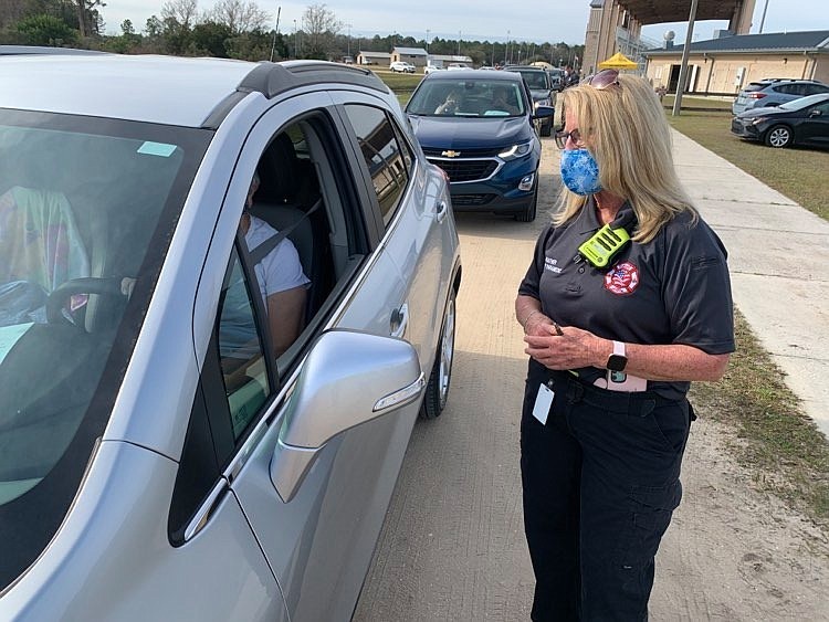 A staff member speaks to a resident at Flagler County's COVID-19 vaccination site at the county fairgrounds. Photo by Brian McMillan