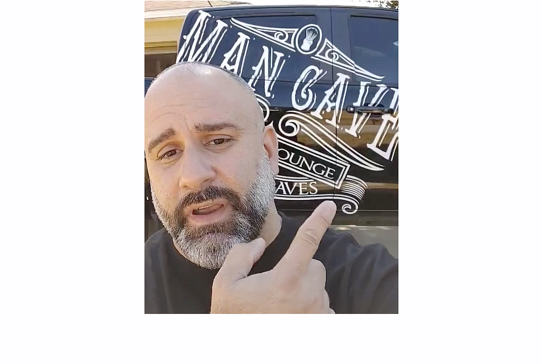 Palm Coast City Councilman Victor Barbosa gestures at his truck during a Facebook video he recorded about Palm Coast's signage restrictions.