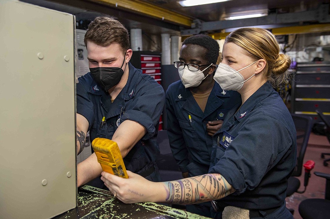 Mathew Mwaura, center, helps perform maintenance on the USS Dwight D. Eisenhower. Photo by Mass Communication Specialist Seaman Jacob Hilgendorf