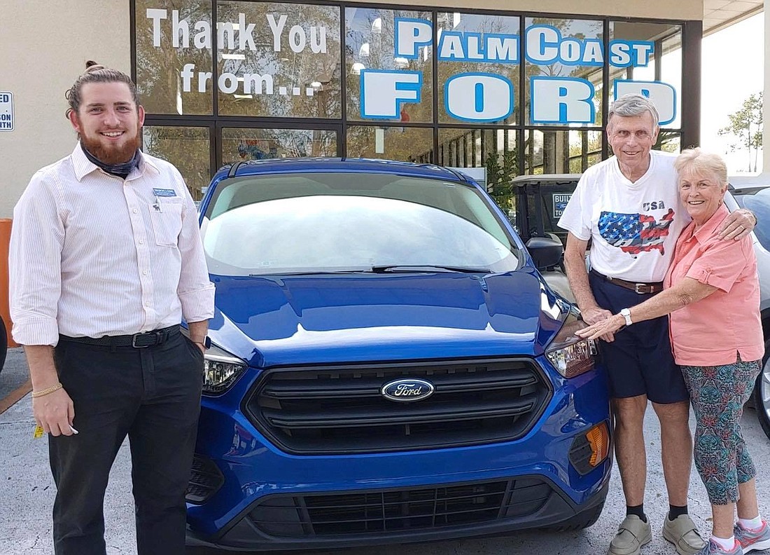 Palm Coast Ford Product Specialist Mason Lowe helps customers Malcolm and Anne Fraser buy a Ford Escape. Courtesy photo