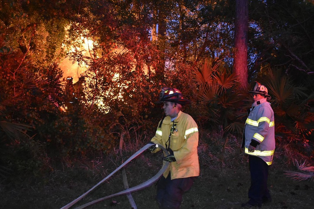 City of Palm Coast firefighters deploy a handline at a B-Section brush fire allegedly started by a 14-year-old girl. Photo courtesy of the city of Palm Coast