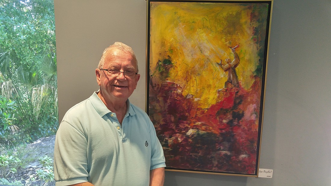 Mike Gleason with one of his paintings. Photo by Brent Woronoff