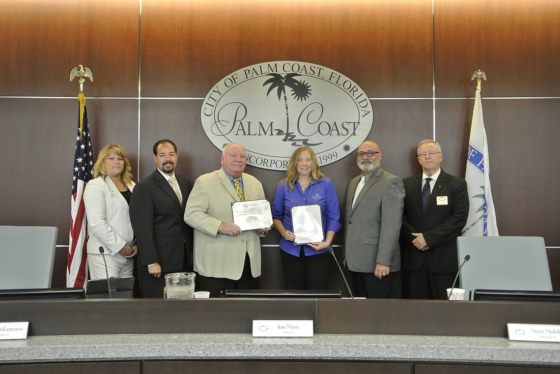 Urban Forester Carol Mini, in blue, presents the Sterling Tree City USA award to the Palm Coast City Council. From left to right: Heidi Shipley, Jason DeLorenzo, Jon Netts, Carol Mini, Steven Nobile and Bill McGuire. (Courtesy photo)