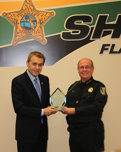 Flagler County Sheriff Jim Manfre, right, presented a plaque of appreciation to Dr. Caesar DePaco for his donations to the new employee gym. (Courtesy photo)