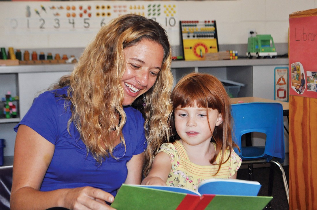 Sarah Schebel reads to 4-year-old Natasha Antoniuk.