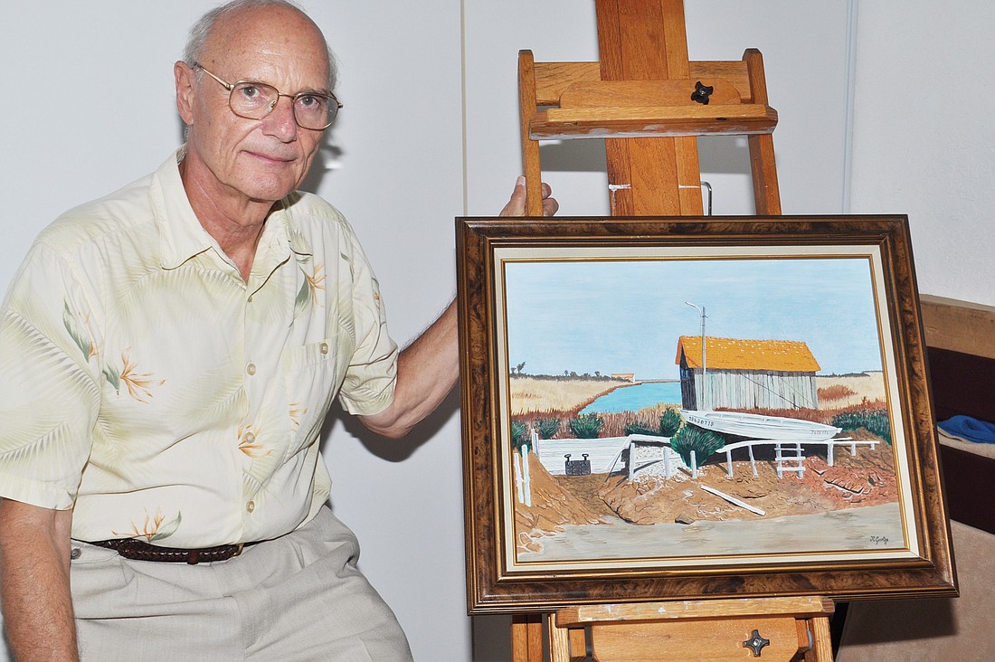 Jean-RenÃƒÂ© Goetze sits near his portable easel with a painting of an oyster shack in France.