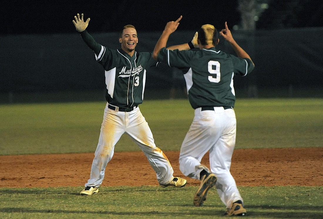 Senior pitcher Brandon King, right, runs out to celebrate with sophomore Justin Greenaway who drove in the game-winning run in the bottom of the eighth inning of the Class 6A-District 12 championship April 27.