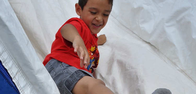 Robert Navarro, 5, raced down the slide with his friend, Jonathan Centeno, not pictured.