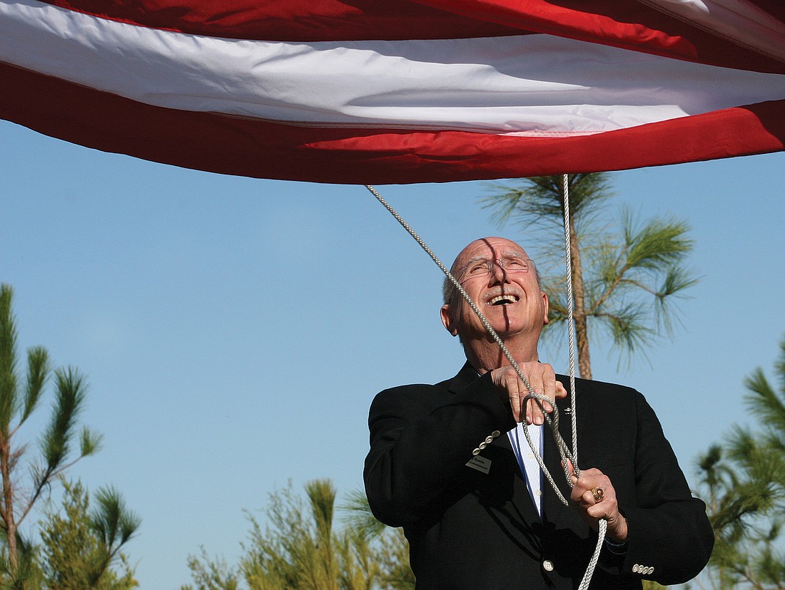 Larry Bustle raised the flag during the opening of Bennett Park. File photo.