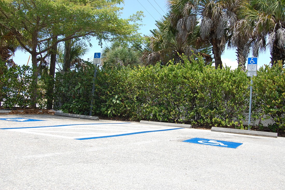 Fresh paint dries on regular and handicap parking spots in the Siesta Key Village parking lot.